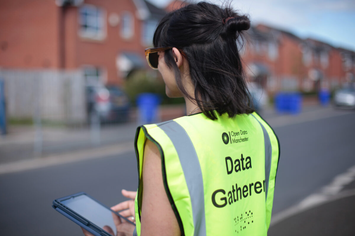 Woman wearing a hi-viz vest that has 'Data Gatherer' written on the back