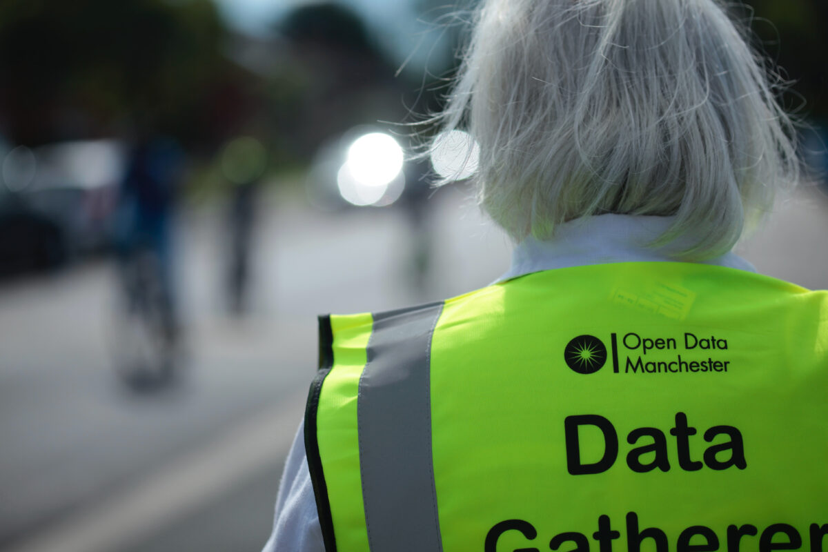 Woman wearing a hi-viz vest that has 'Data Gatherer' written on the back