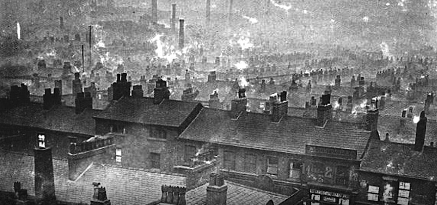 A black and white photo of a street of houses.