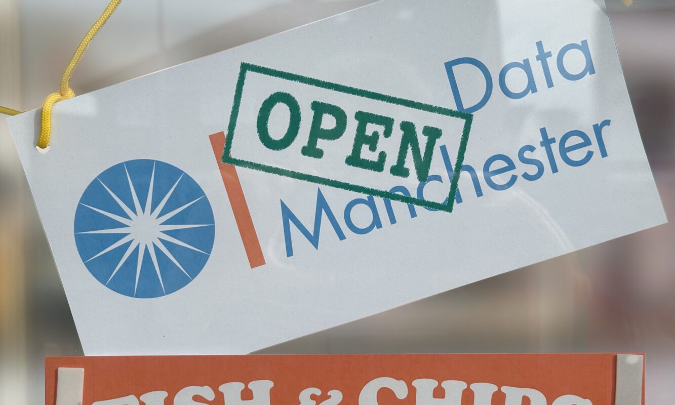 Open Data Manchester logo with a green Open stamp on it printed out and stuck on a chip shop window